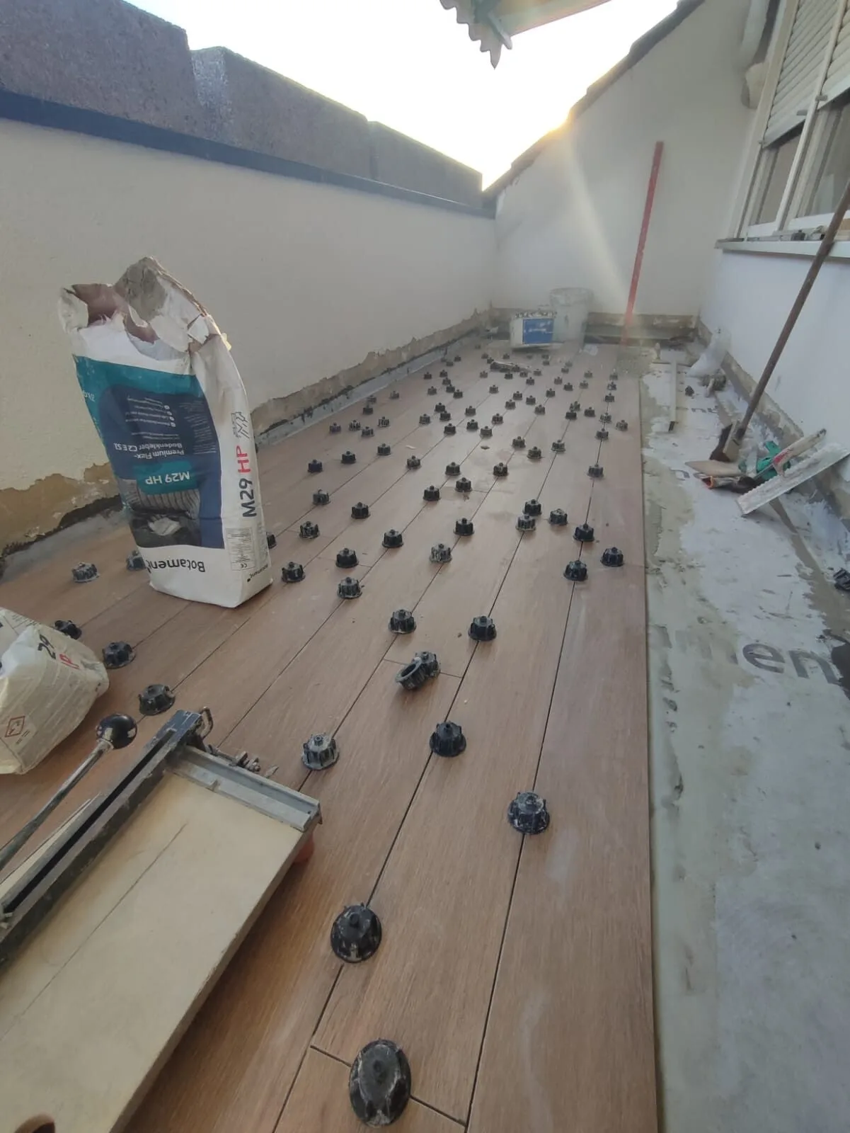 Balkon in Holzoptik während der Verlegung mit Nivelliersystem