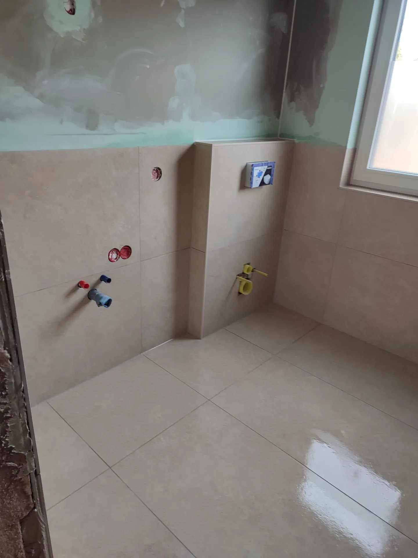 Dachbad nach der Verlegung — beige Großformatfliesen, WC-Vorwand