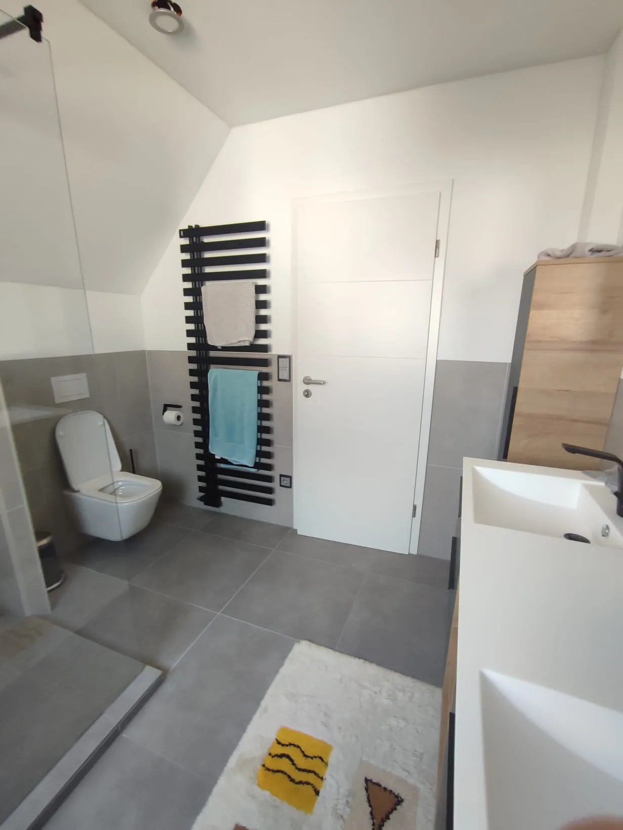 WC-Bereich mit schwarzem Handtuchheizkörper